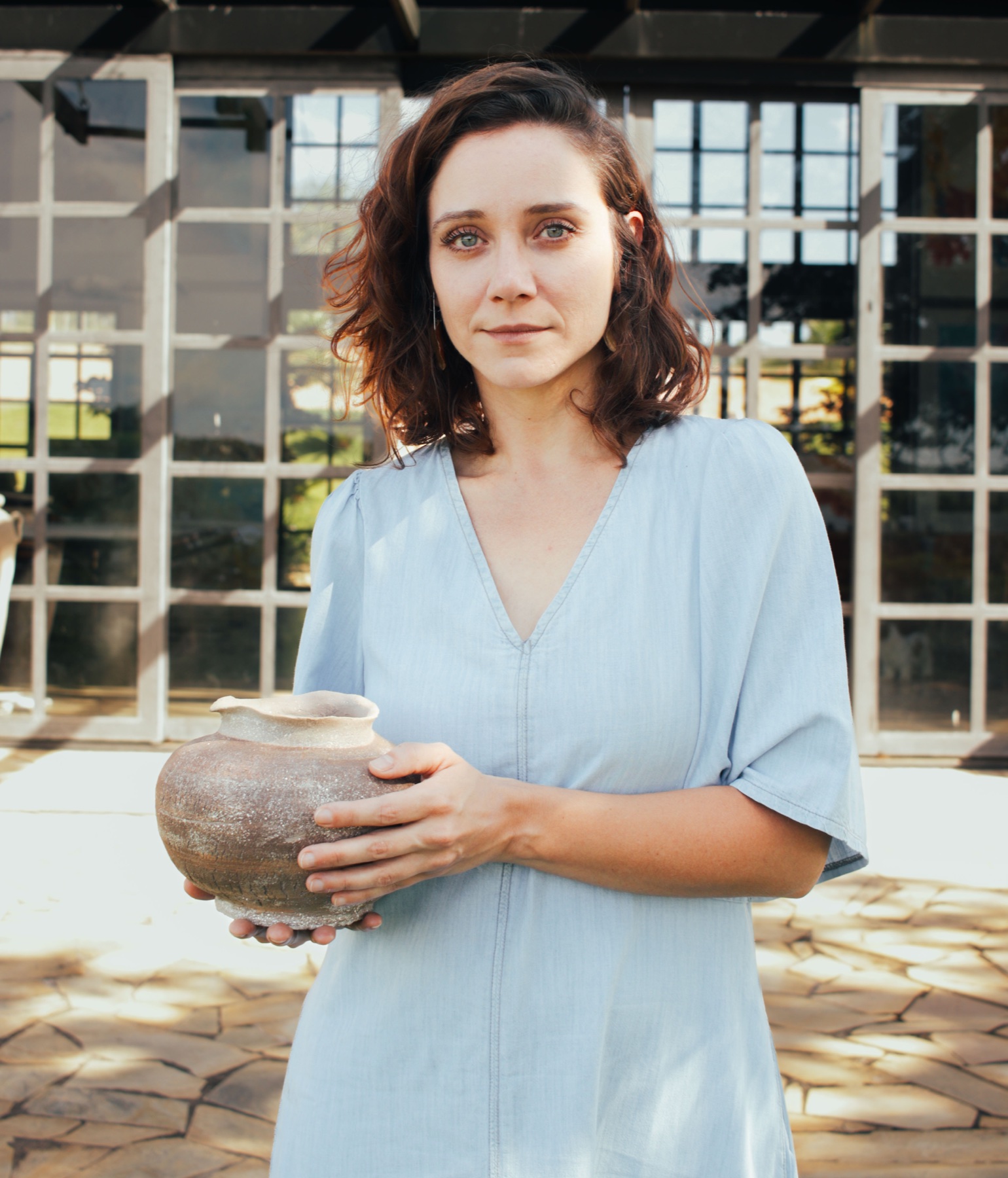 Amanda Maciel segurando uma peça de cerâmica